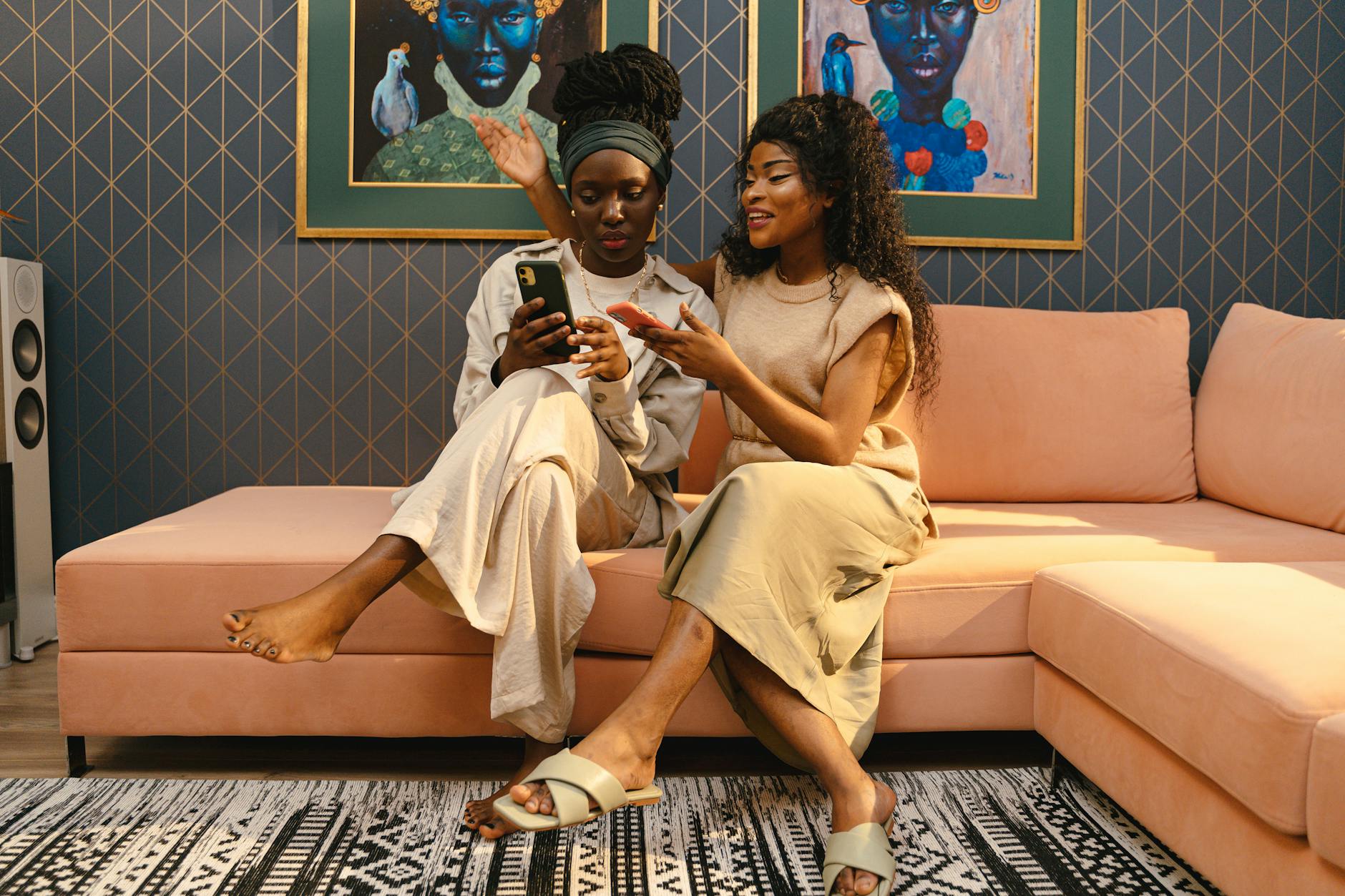 Pic of two woman laughing on sofa.